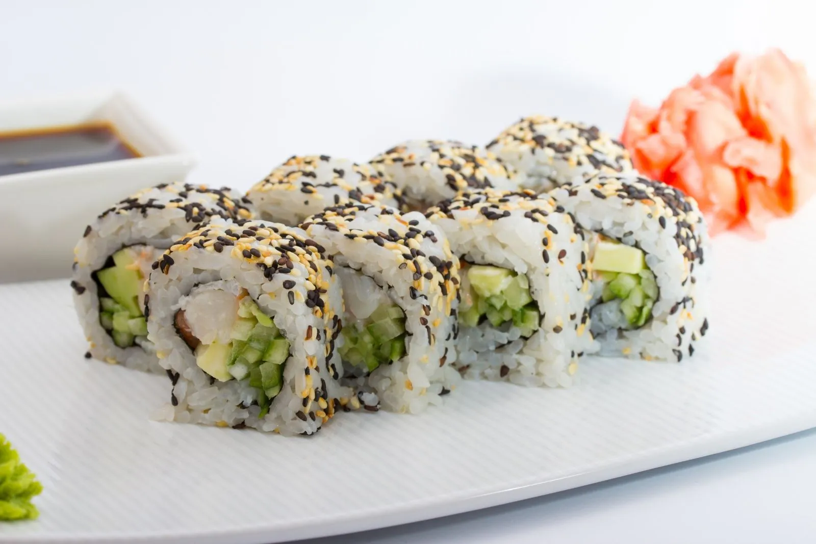 Shrimp sushi rolls coated in black and white sesame seeds with cucumber filling